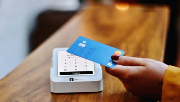 a person holding a credit card in front of a machine