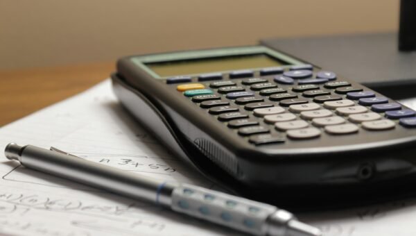 a calculator and a pen sitting on top of a piece of paper